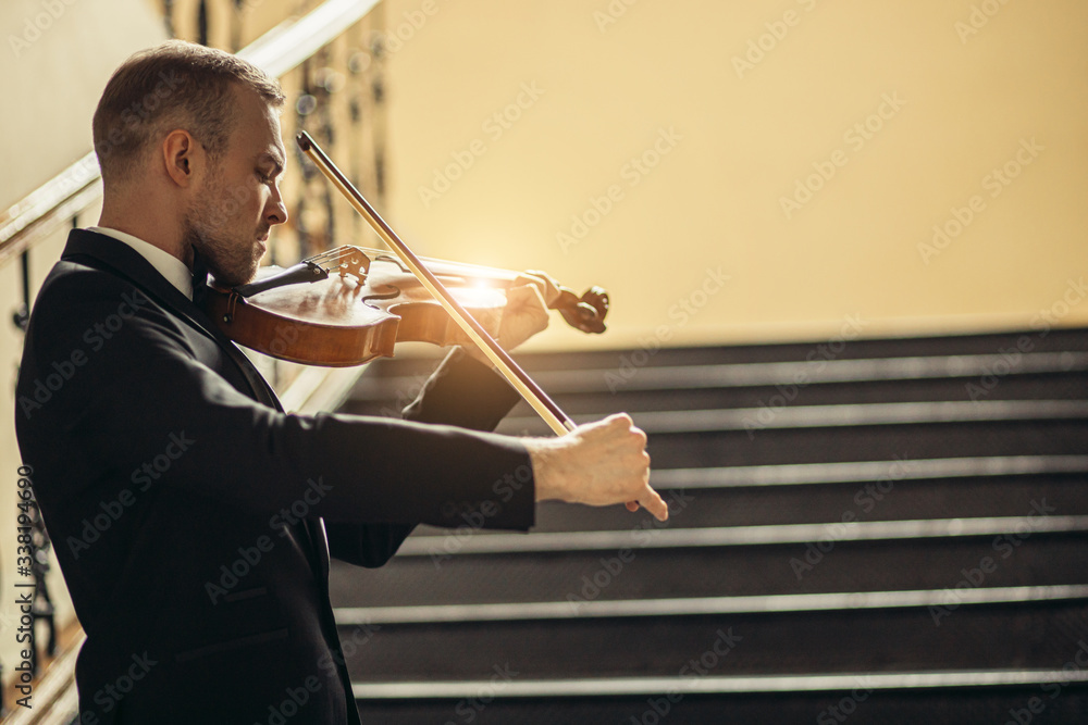 talented professional caucasian male violinist play in the hall