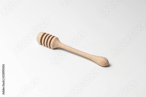 Wooden honey dipper isolated on white background. Close-up, copy space