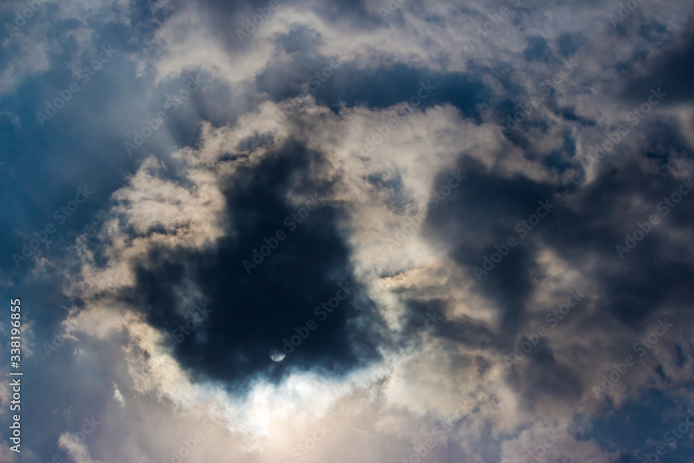 Fototapeta premium The sun in the blue sky closed by thin clouds 