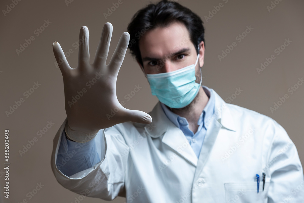Virus mask male doctor wearing face protection in prevention for coronavirus showing gesture Stop Infection