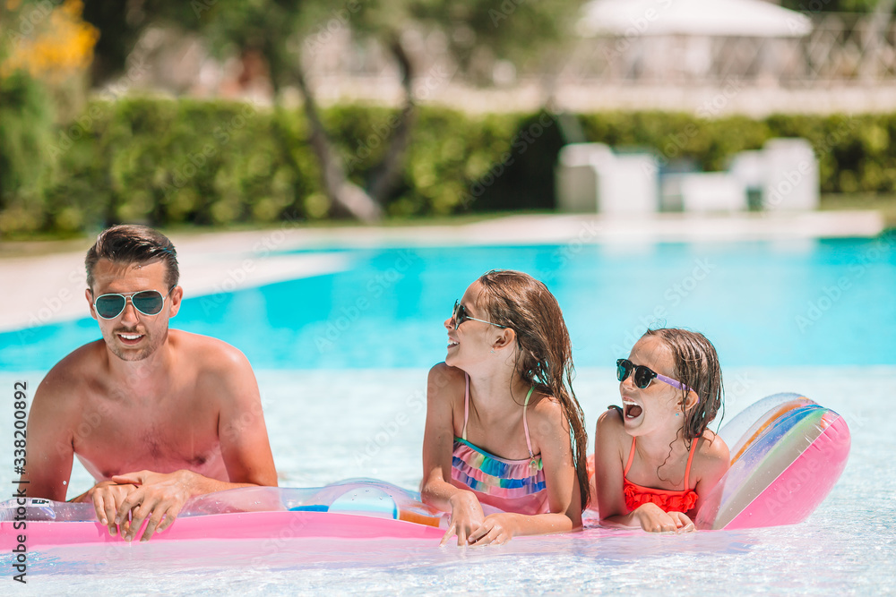 Fototapeta premium Happy family of three in outdoors swimming pool