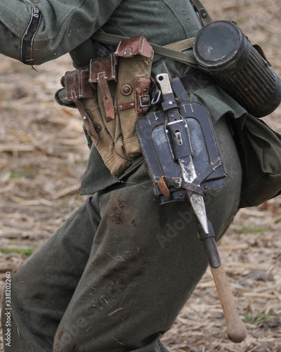 German WWII Wehrmacht reenactor wearing a Folding Shovel Klappspaten (Foldable Spade) with Leather Carry Cover and Sturmgewehr 44 canvas magazine holders.