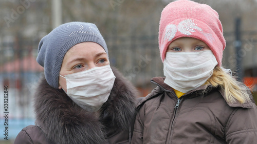 girl with mather in the street in antiviral mask