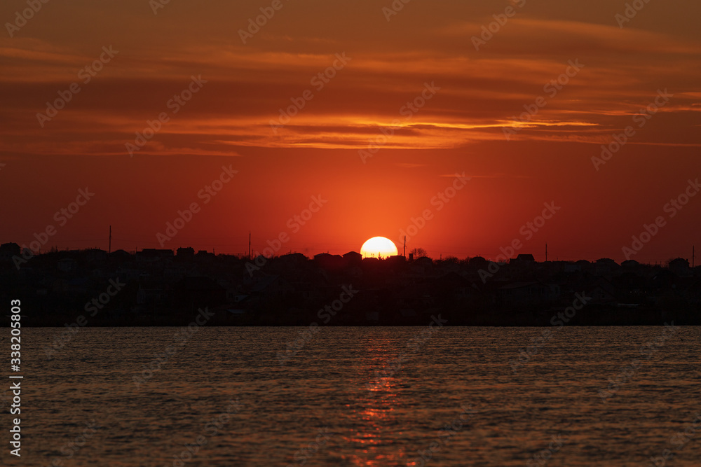 Fototapeta premium Beautiful sunset on the lake with clouds and reflections on the water