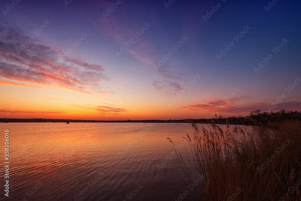 Beautiful sunset on the lake with clouds and reflections on the water Beautiful sunset on the lake with clouds and reflections on the water