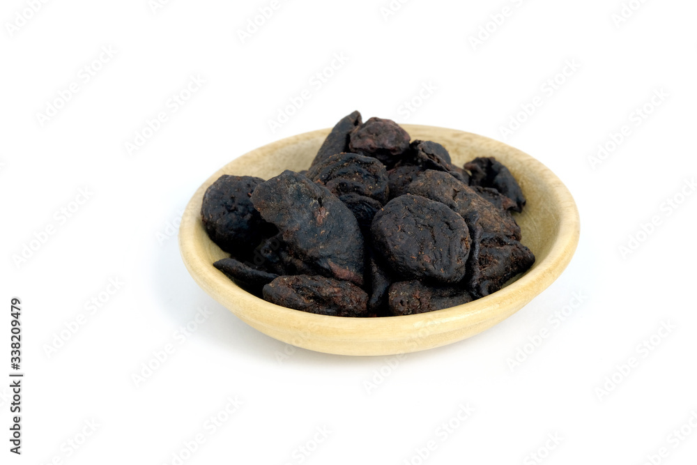 Closeup garcinia cochinchinensis (called Asam kandis in Indonesia) on wooden plate isolated white background Closeup garcinia cochinchinensis (called Asam kandis in Indonesia) on wooden plate isolated white background