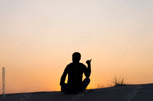 silhouette photo man sitting on sky background