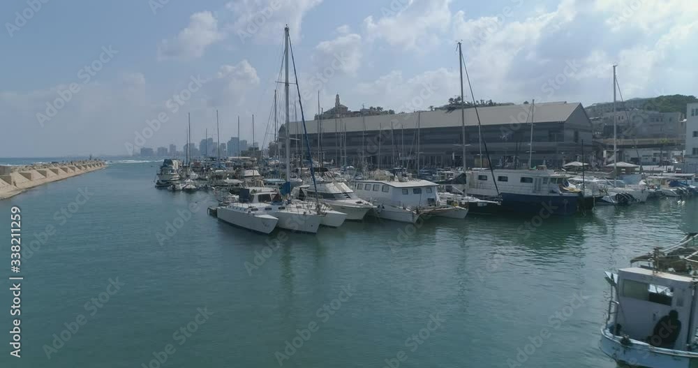 Aerial view above port marina bay with Boats And Yachts Parking or Moored. Mediterranean Tourism Travel shot with Tel aviv Jaffa at the background Aerial view above port marina bay with Boats And Yachts Parking or Moored. Mediterranean Tourism Travel shot with Tel aviv Jaffa at the background