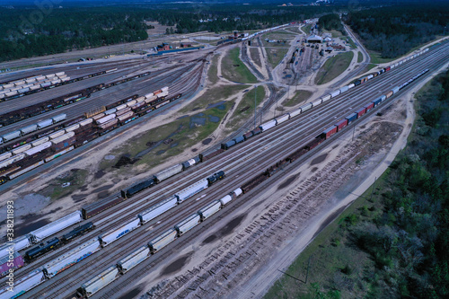 Aerial view of a staging yard at a large train center. Lots of railroad cars line the tracks of the complex.