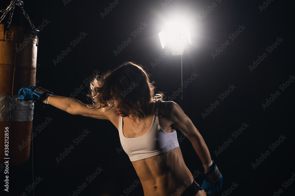 Young sexy Woman boxer. Martial arts or self defence.  Fitness girl training kick boxing. Boxing training on ring. Confident athlete woman in boxing gl