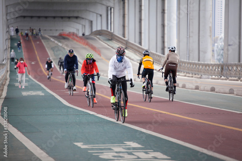 people on the street cycling wearing mask during Covid 19 pandemic in Korea