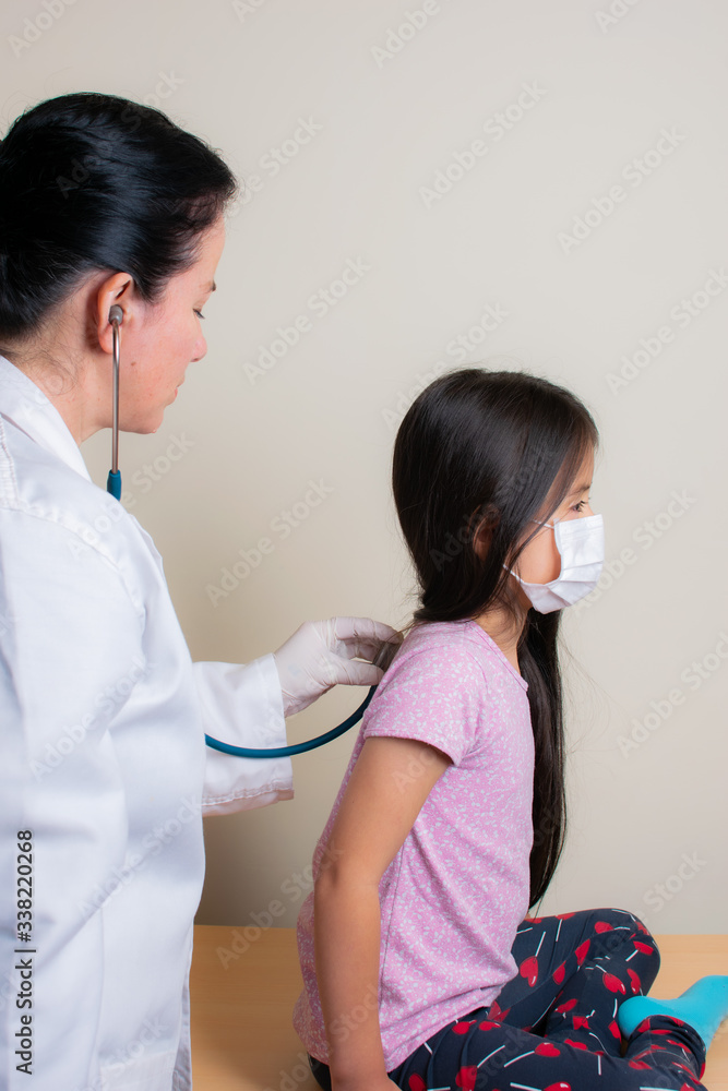 Colombian girl is examined by her pediatrician in the consulting room Colombian girl is examined by her pediatrician in the consulting room