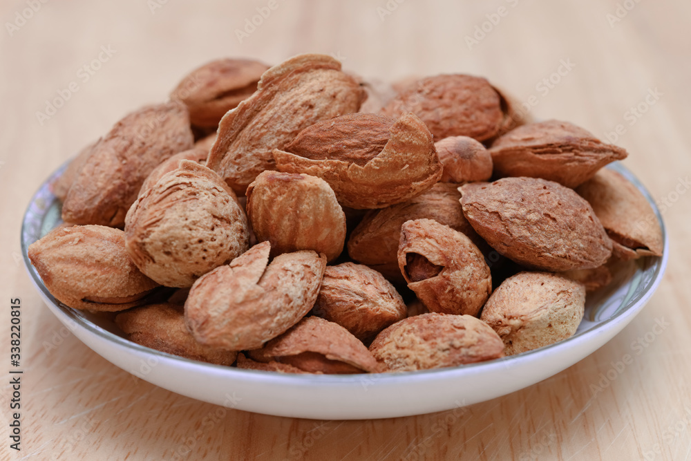 side view dish of almond nuts side view dish of almond nuts