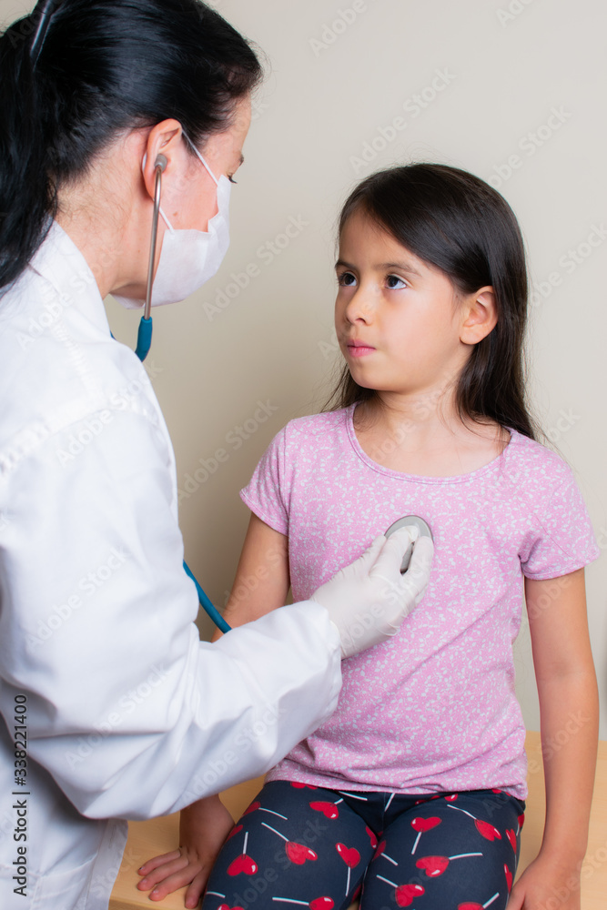 Colombian girl is examined by her pediatrician in the consulting room Colombian girl is examined by her pediatrician in the consulting room