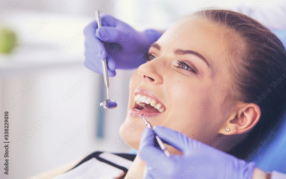 Young Female patient with open mouth examining dental inspection at dentist office. Young Female patient with open mouth examining dental inspection at dentist office.