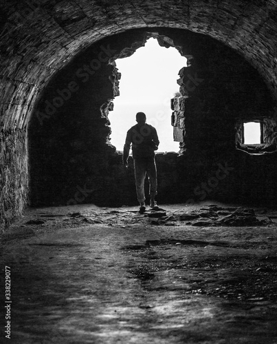 Man explores old ruins by the coast