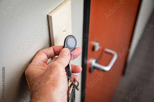 Tableau sur toile Close up of hand holding key FOB to gain access to an interior office door