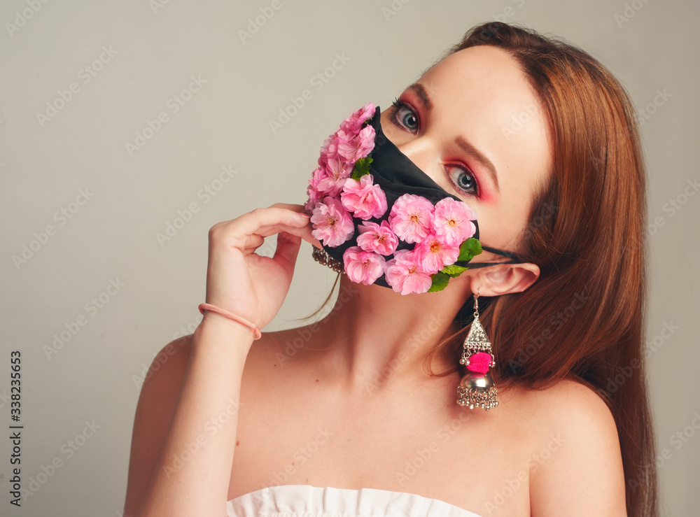 Girl with gorgeous long hair in an antiviral mask. Fashion photo on the cover of the magazine. Pandemic, virus, coronavirus, masked girl spring has come. Spring fashion, model in a mask of flowers Girl with gorgeous long hair in an antiviral mask. Fashion photo on the cover of the magazine. Pandemic, virus, coronavirus, masked girl spring has come. Spring fashion, model in a mask of flowers
