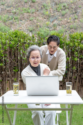 Using a laptop to wear an Asian elderly couple