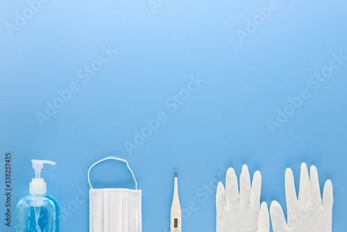 Medical supplies to protect and stay safe from COVID-19 on light blue background top view border design with copy space