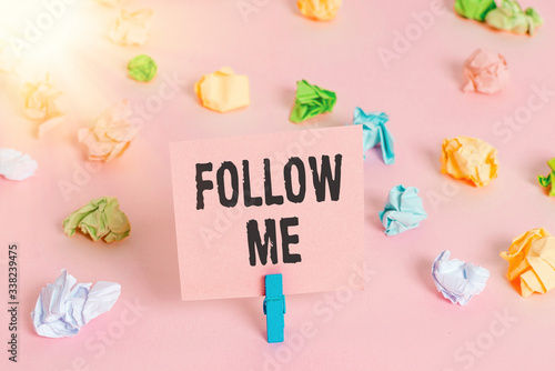 Text sign showing Follow Me. Business photo showcasing Inviting a demonstrating or group to obey your prefered leadership Colored crumpled papers empty reminder pink floor background clothespin © Artur