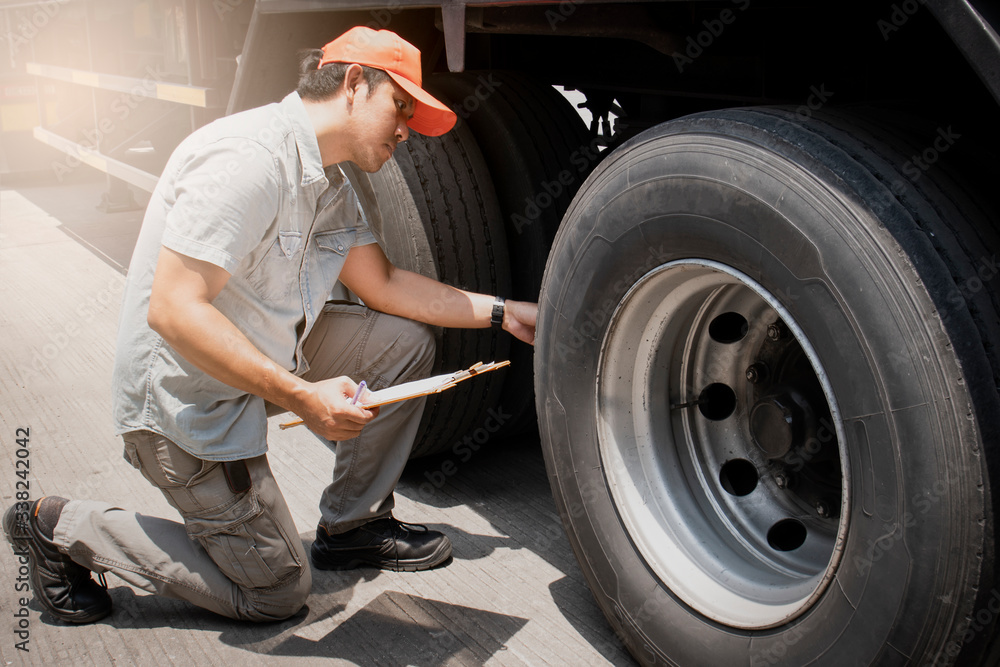Auto Mechanic is Checking the Truck's Safety Maintenance Checklist. Fixing. Inspection Safety of Semi Truck Wheels Tires.	