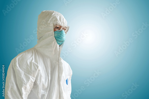 Medical personnel in half protective clothing uniform PPE suit and Surgical mask or hygienic mask N95 isolated on blue background, During coronavirus covid-19 outbreak, Concept of pandemic virus.