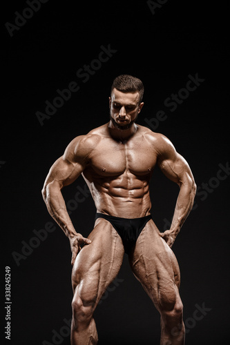 Muscular athletic bodybuilder fitness model posing. Isolated on black. Sport photo with dramatic light