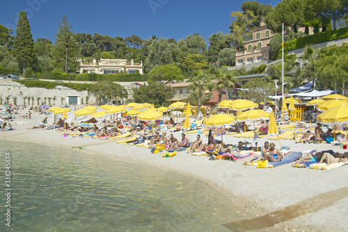 Canvas Print Sunbathers on beach on French Riviera, France
