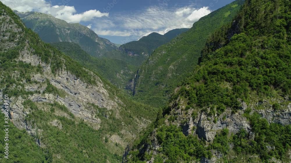 Bird’s eye view epic famous gorge Jupshar canyon Abkhazia attraction among mountains. Natural alpine Caucasus landscape steep rocky cliffs slopes highest peaks covered spruce forest. Blue sky clouds Bird’s eye view epic famous gorge Jupshar canyon Abkhazia attraction among mountains. Natural alpine Caucasus landscape steep rocky cliffs slopes highest peaks covered spruce forest. Blue sky clouds