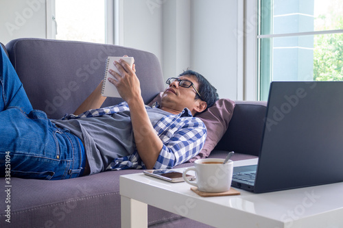 Men work or study online stay home lying relaxed on the sofa. Is a way to solve common problems with society reducing the spread of the covid-19 virus. work from home and stay home