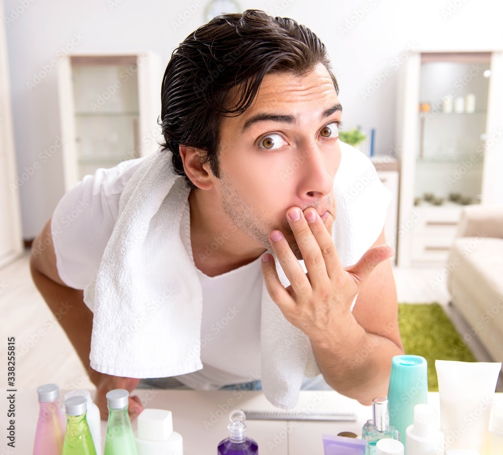 Young handsome man in the bathroom in hygiene concept Young handsome man in the bathroom in hygiene concept