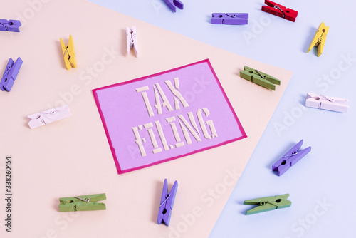 Handwriting text Tax Filing. Conceptual photo Submitting documens filed with tax payer financial information Colored clothespin paper empty reminder yellow blue floor background office photo