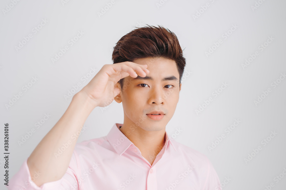 Young Asian man wearing pink shirt over white background. Young Asian man wearing pink shirt over white background.