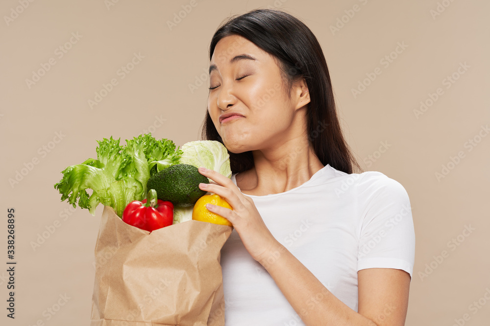 young woman holding a shopping bag full of groceries young woman holding a shopping bag full of groceries