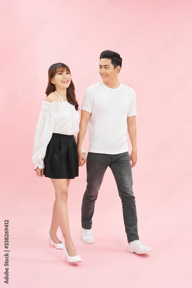 Follow me! Studio shot of beautiful young couple walking together and holding hands Follow me! Studio shot of beautiful young couple walking together and holding hands
