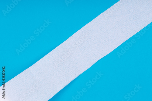Toilet paper roll on the bright blue background. Coronavirus COVID-19 pandemic panic shopping, social distancing concept. Bright monochrome drop with diagonal line and place for text