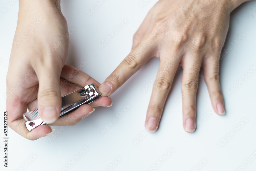 Man using nail clipper clipping her fingernails. white background Man using nail clipper clipping her fingernails. white background