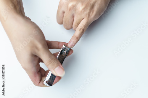 Man using nail clipper clipping her fingernails. white background
