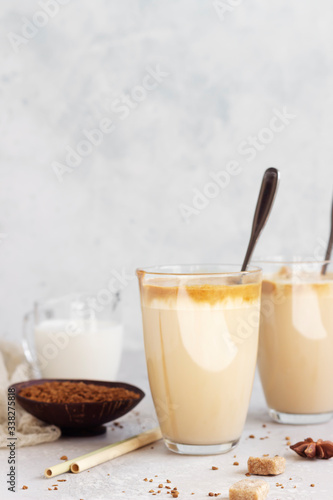 Tasty fresh iced coffee, Dalgona coffee. Trend Korean drink with instant coffee in glass on light grey table. 