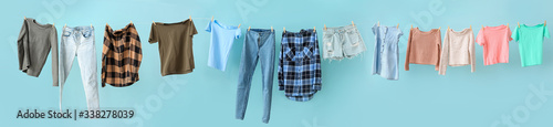Clean laundry hanging on line against color background