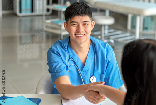 Male Asian doctor shaking h...