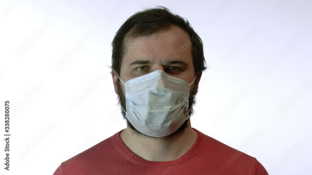 Man in medical mask nervously standing and looks at camera. Panic of coronavirus Man in medical mask nervously standing and looks at camera. Panic of coronavirus
