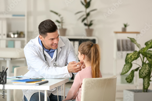 Pediatrician examining little girl in clinic