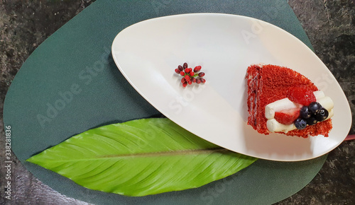 strawberry cake on a white plate and big leaf