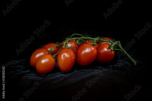 fresh red tomatoes isolated on dark background. Front view