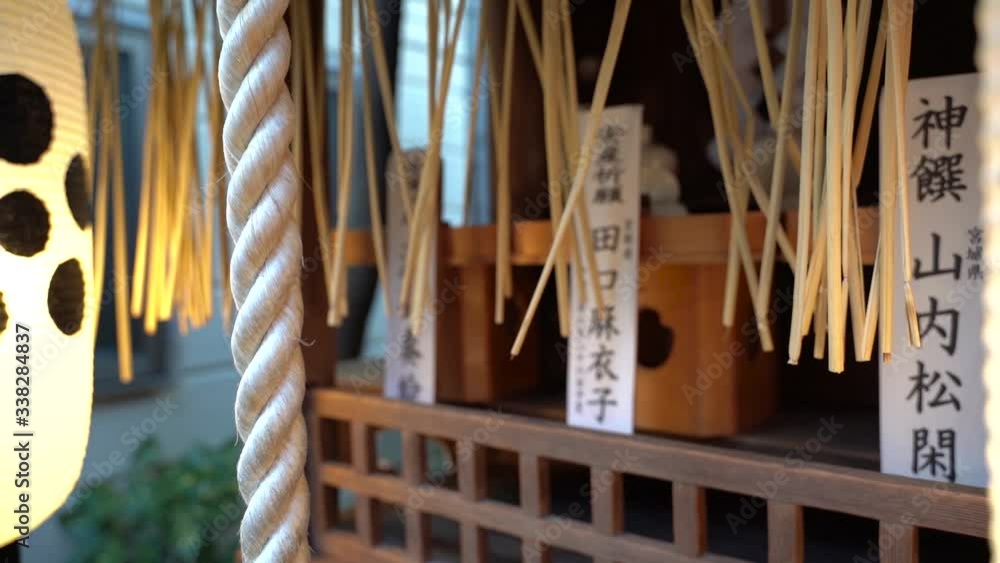 Closeup View Of A White Rope And Japanese Lanterns Hanging Outside The Small Shrine In Japan - Slow Motion Sliding Shot Closeup View Of A White Rope And Japanese Lanterns Hanging Outside The Small Shrine In Japan - Slow Motion Sliding Shot