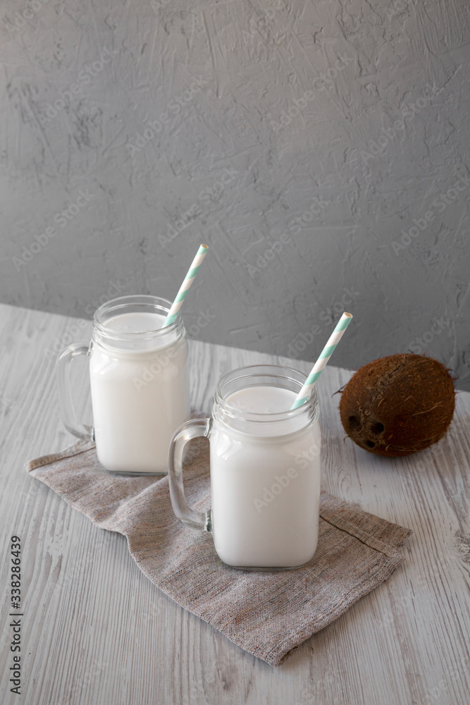 Coconut milk in glass jars, side view. Copy space. Coconut milk in glass jars, side view. Copy space.