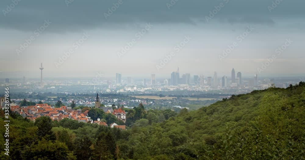 A historical German town in front of Frankfurt´s modern skyline. Dark moving clouds, viewed from the Taunus hills. A historical German town in front of Frankfurt´s modern skyline. Dark moving clouds, viewed from the Taunus hills.
