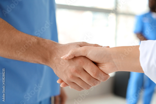 Doctors shaking hands in clinic. Unity concept